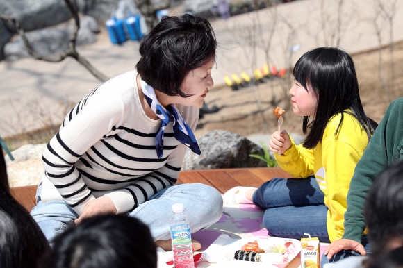 김정숙 여사가 식목일을 하루 앞둔 4일 오전 청와대 경내 유실수단지에서 청와대 인근 초등학교 어린이들을 초청해 함께 우리꽃나무를 심은후 도시락을 먹고 있다. 2019.4.4  청와대 제공