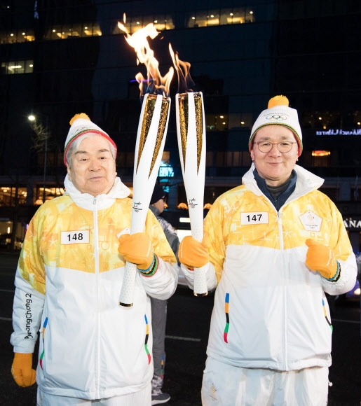 2018년 1월 18일 서울 중구 광화문에서 아들 조원태 대한항공 사장과 평창동계올림픽 성화를 봉송하는 조 회장(왼쪽).  연합뉴스