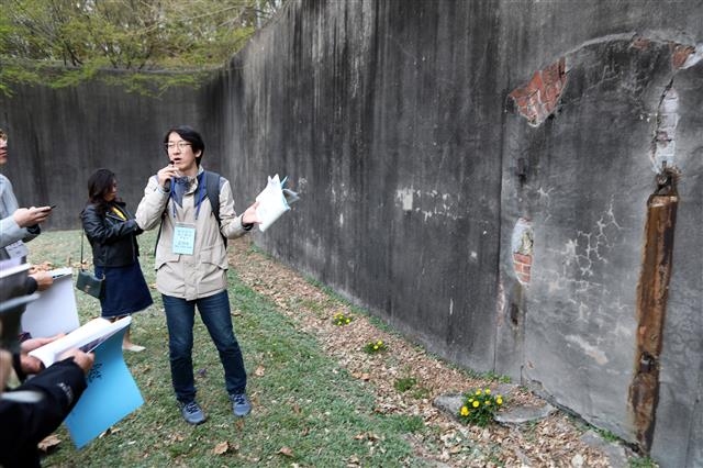 김천수 용산문화원 용산문화실장이 일제강점기부터 군 감옥으로 사용된 위수감옥에 대해 설명하고 있다. 담장 일부 콘크리트가 떨어져 나간 곳에 일본군이 지은 벽돌벽이 드러나 있다. 국토교통부 제공