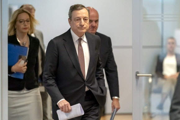 마리오 드라기 유럽중앙은행(ECB) 총재(가운데)가 10일(현지시간) 독일 프랑크푸르트에서 열린 통화정책회의를 마친 뒤 기자회견을 위해 들어서고 있다.  프랑크푸르트 EPA 연합뉴스