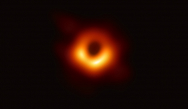 마침내 블랙홀이 인류에게 모습을 드러냈다. 이벤트 호라이즌 망원경(EHT) 프로젝트 국제연구진이 사상 처음으로 촬영한 블랙홀 M87의 모습을 10일 공개했다. 지구에서 5500만 광년 떨어진 곳에 있는 이 블랙홀의 가운데 검은 부분은 블랙홀과 블랙홀을 포함하는 그림자이고 고리의 빛나는 부분은 블랙홀의 중력에 의해 휘어진 빛이다. EHT 제공