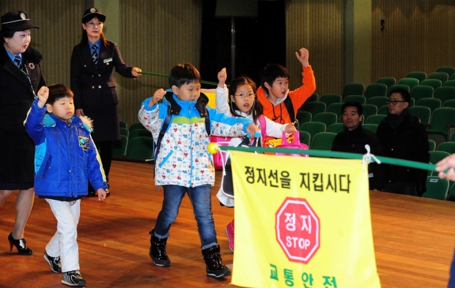 지난 2012년 서울 서초구민회관에서 열린 새내기학부모 교실에서 어린이들이 녹색어머니회 회원의 안내를 받아 길을 건너는 연습을 하고 있다.  서울신문 DB