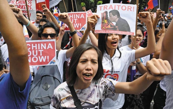사진설명: 필리핀 시민들이 지난 9일 수도 마닐라 외곽 마카티 중국 영사관 앞에서 ‘중국은 당장 떠나라’,‘두테르테는 반역자’라고 쓰인 피켓들을 들고 격렬한 반중 시위를 벌이고 있다. 마닐라 AFP 연합뉴스