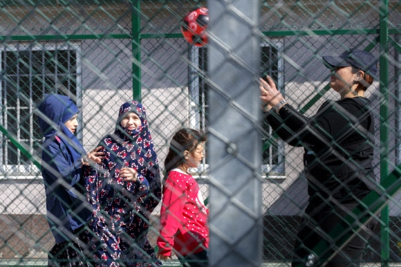 코소보의 한 여자 경찰관(오른쪽)이 시리아의 쿠르드 세력에 감금됐다가 20일(현지시간) 귀국해 브라니돌 마을의 외국인 구금 센터에 수용된 코소보 어린이들과 어울려 사진을 찍고 있다. 브라니돌 EPA 연합뉴스 