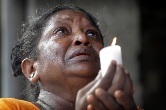 부활절 연쇄 폭발 테러가 발생한 스리랑카 수도 콜롬보의 성 안토니오 성당 인근에서 지난 23일 전국적인 ‘3분간의 묵념’에 참여한 한 여성이 촛불을 든 채 눈물을 흘리고 있다. 콜롬보 AP 연합뉴스