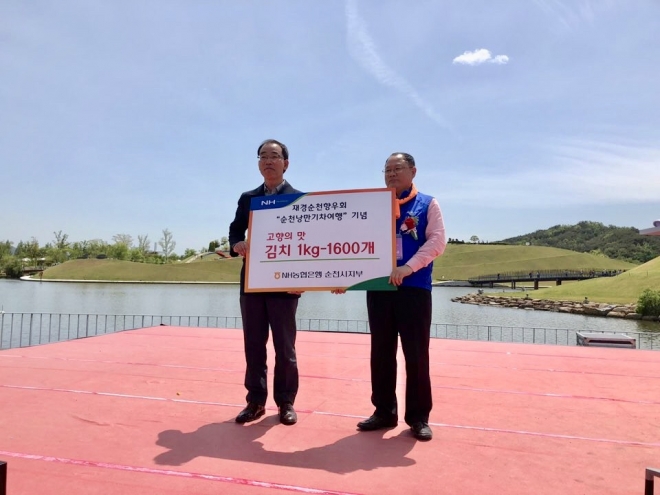 김회천(왼쪽) 농협 순천시지부장이 최대규 재경향우회장에게 순천김치 1600개를 전달하고 있다.
