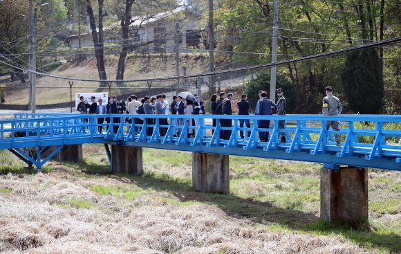 판문점 공동경비구역(JSA) 견학이 재개된 1일 관광객들이 지난해 4·27 남북 정상회담 당시 문재인 대통령과 김정은 북한 국무위원장이 친교 산책 후 대화를 나눴던 도보다리를 걷고 있다.  판문점 사진공동취재단