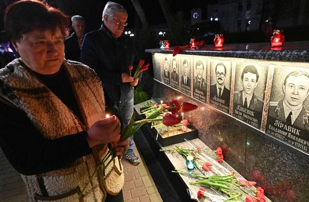 지난달 체르노빌 참사 33주년을 맞아 추모객들이 당시 희생된 이들의 영정 사진 앞에 꽃을 놓아 두고 있다. AFP 자료사진