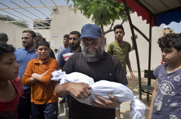 한 남자가 6일 이스라엘의 가자지구 미사일 공습으로 숨진 생후 4개월의 팔레스타인 여아를 품에 안고 울고 있다. AP=연합뉴스