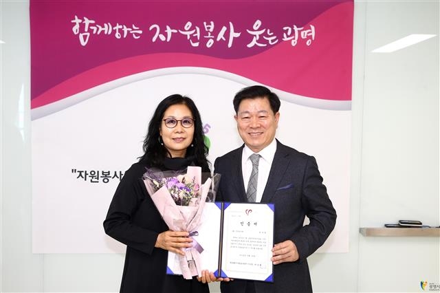 지난 1월 ‘이달의 신규 봉사왕’에 선정된 원선희(왼쪽)씨가 박 시장과 기념사진을 찍고 있다.  광명시 제공