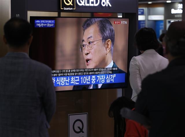 시민들이 9일 서울역 대합실에서 문재인 대통령의 취임 2주년을 맞아 KBS가 오후 8시 30분부터 80여분간 생방송으로 진행한 ‘대통령에게 묻는다’ 특집 대담을 시청하고 있다.  뉴스1