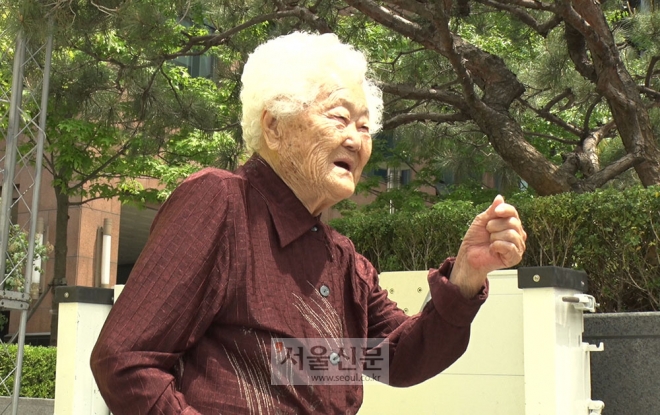 15일 정오 서울 종로구 옛 일본대사관 앞에서 열린 제1387회 수요집회에 참석한 이옥선 할머니가 기념 촬영 중 손 하트를 만들어 보이고 있다.