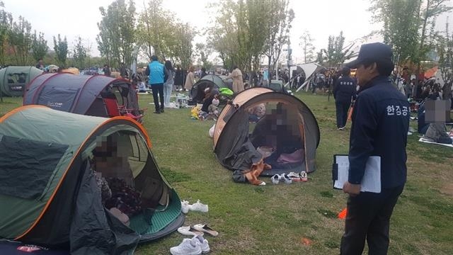 여의도 한강공원에서 단속원이 오후 7시가 지나고도 철거하지 않은 텐트를 단속하고 있다.  연합뉴스