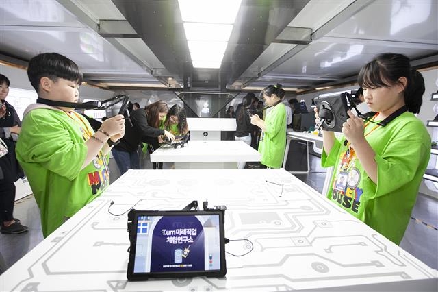 강원 고성군 인흥초등학교에 마련된 SK텔레콤 이동식 정보통신기술(ICT) 체험관 ‘티움 모바일’에서 학생들이 가상현실(VR), 증강현실(AR) 기술이 적용된 직업 체험 놀이를 하고 있다.  SK텔레콤 제공