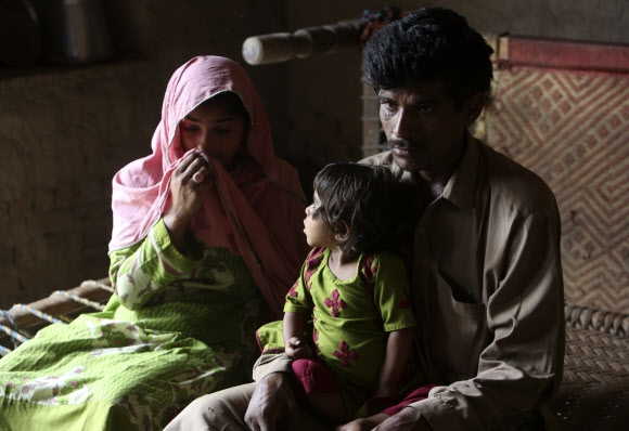 파키스탄 남부 신드주의 라르카나 지역의 한 의사가 주사기를 재사용해 주민 500명 이상이 인체면역결핍바이러스(HIV)에 집단감염된 가운데, 3살 난 딸을 포함해 가족이 전부 HIV에 감염된 가족이 인터뷰를 하고 있다. 2019.5.17  AP 연합뉴스