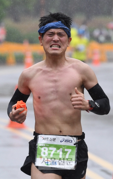 한 남성 참가자가 웃옷을 벗은 채 비를 맞으며 역주하고 있다. 박윤슬 기자 seul@seoul.co.kr