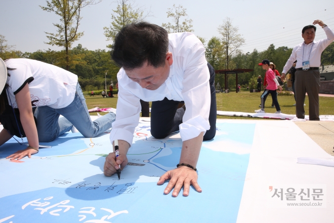 박승원 광명시장이 평화공원에서 대형현수막에 소원을 쓰고 있다. 광명시 제공
