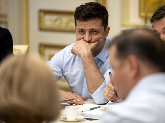 볼로디미르 젤렌스키(가운데) 우크라이나 대통령이 21일(현지시간) 수도 키예프에서 일부 의원들과 의회 해산에 대한 논의를 하던중 생각에 잠겨있다.  키예프 AP 연합뉴스