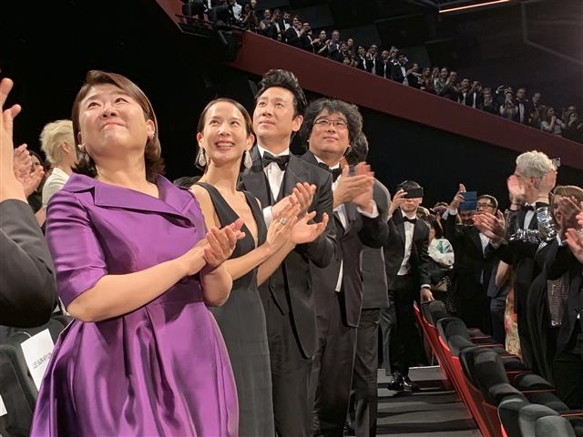 지난 21일(현지시간) 프랑스 칸 뤼미에르 대극장에서 열린 영화 ‘기생충’ 공식 상영 후 8분간 이어진 관객들의 기립박수에 봉준호(왼쪽에서 네 번째) 감독을 비롯한 배우 이정은(왼쪽부터), 조여정, 이선균이 박수로 화답하고 있다.  CJ엔터테인먼트 제공