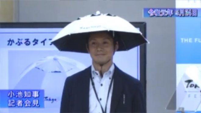 지난 24일 고이케 유리코 도쿄도 지사의 기자회견에서 한 도쿄도청 직원이 모자형 양산 시제품을 쓰고 시연하고 있다. 도쿄도 홍보영상 캡처