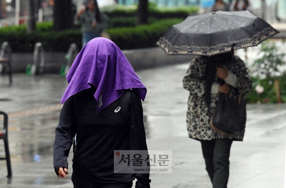 전국적으로 비가 내린 27일 서울 광화문 광장 인근에서 우산을 준비하지 못한 한 시민이 수건으로 얼굴을 덮은 채 길을 걷고 있다 . 기상청은 흐린 가운데 온종일 비가 오다가 늦은 오후 북서쪽지방부터 그치기 시작해 늦은 밤에는 전국 대부분이 그칠 것으로 예보했다. 2019. 5. 27.  박윤슬 기자 seul@seoul.co.kr