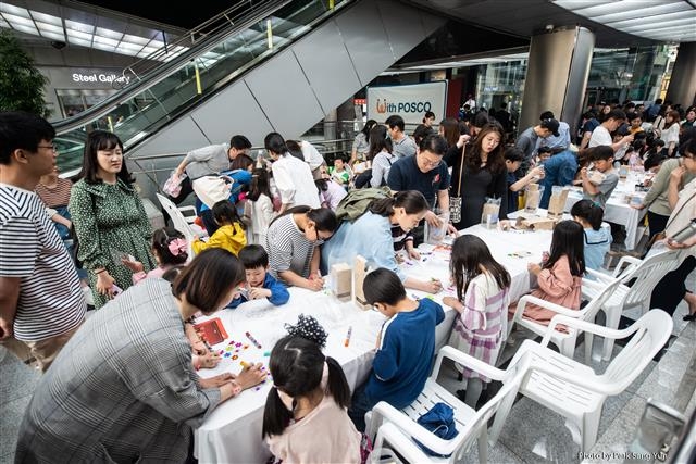 가정을 달을 맞아 지난 11일 서울 포스코센터에서 열린 ‘포스코키즈콘서트’에 참여한 어린이들이 부대행사로 진행된 ‘나만의 스틸 텀블러 만들기’ 체험을 하고 있다.  포스코 제공