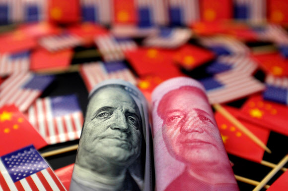미 건국의 아버지 중 한 명인 벤저민 프랭클린이 도안된 100달러 지폐와 중국 초대 국가주석 마오쩌둥이 새겨진 100위안 지폐가 양국 국기에 둘러싸여 있는 모습. 로이터 연합뉴스