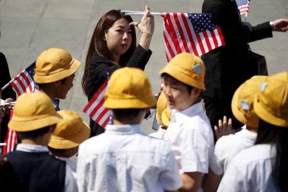 지난 27일 일본 도쿄 지요다구 왕궁에서 열린 도널드 트럼프 미국 대통령 환영행사에 동원된 인근 반초초등학교 6학년 학생들. AP 연합뉴스