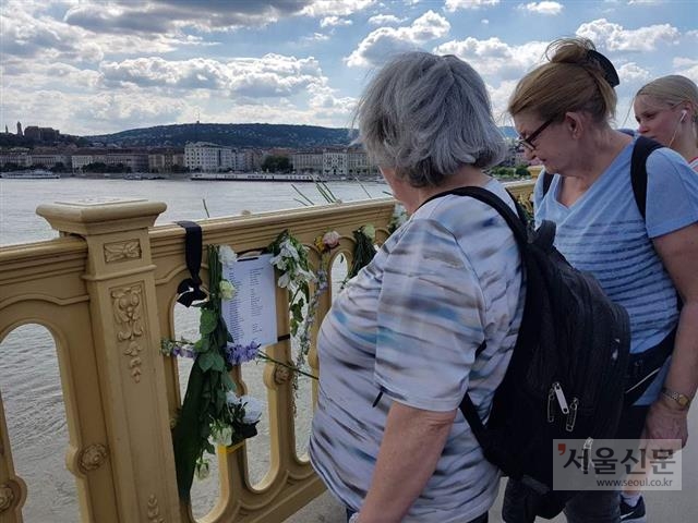 헝가리 부다페스트 다뉴브강 사고지점 인근의 머르기트 다리 위에서 현지 시민들이 헝가리어로 된 추모시를 읽고 있다. 부다페스트 이하영 기자 hiyoung@seoul.co.kr