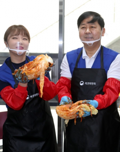 가수 홍진영(왼쪽)과 구윤철 기획재정부 2차관이 3일 오전 서울 동작구 상도동 청운보육원에서 열린 복권위원회 제12기 행복공감봉사단 봉사활동에서 직접 담근 김치를 선보이고 있다. 2019.6.3<br>연합뉴스