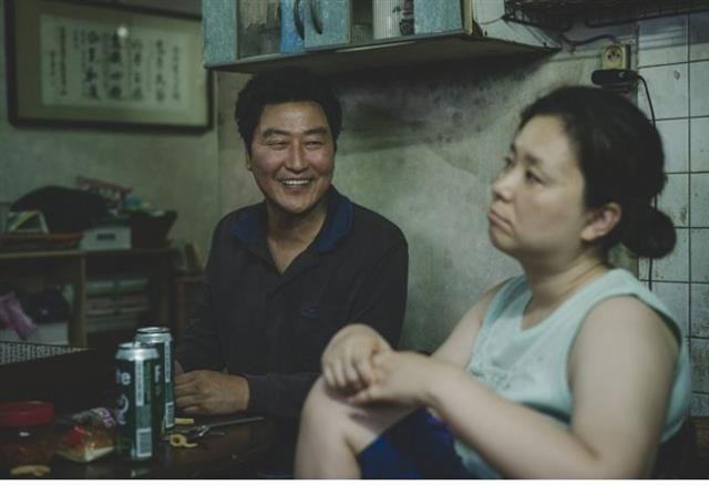 영화 ‘기생충’에서 주인공 기택(송강호·왼쪽)이 아내 충숙(장혜진)과 함께 필라이트를 마시고 있는 모습. 바른손이앤에이 제공