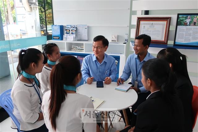 김선규(가운데) WB파이낸스 법인장이 프놈펜 본점에서 직원들과 대화하고 있다.