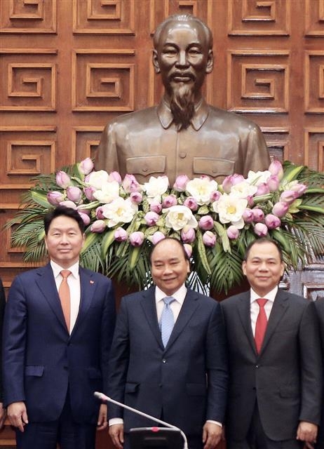 최태원(왼쪽) SK그룹 회장이 지난 5일 베트남 하노이 총리공관에서 응우옌쑤언푹(가운데) 베트남 총리, 팜브엉 빈그룹 회장과 기념사진을 찍고 있다. SK 제공