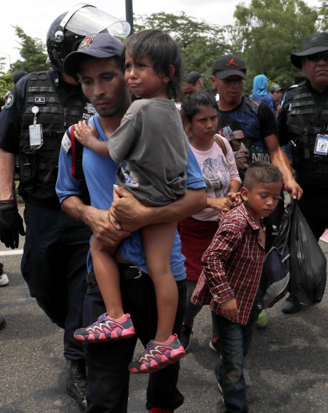 미국 정착을 희망하며 과테말라와 멕시코 국경을 넘은 중미 출신 이민자(캐러밴) 가족들이 5일(현지시간) 국경에서 약 12㎞ 떨어진 치아파스주 메타파에서 멕시코 국경수비대원들에게 저지당해 발길을 돌리고 있다. 메타파 AP 연합뉴스
