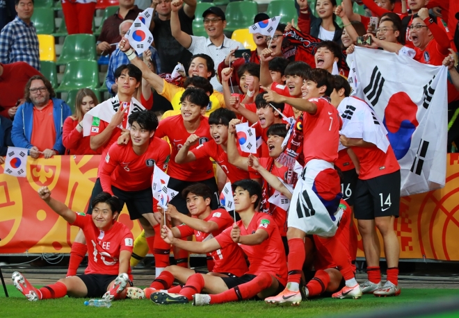 9일(한국시간) 폴란드 비엘스코-비아와 경기장에서 열린 2019 국제축구연맹(FIFA) 남자추구 20세 이하(U-20) 월드컵 8강 세네갈과의 경기에서 대표팀이 승부차기 접전 끝에 4강 진출을 확정하고 그라운드에 앉아 태극기를 들고 기뻐하며 기념촬영을 하고 있다. 2019.6.9 연합뉴스