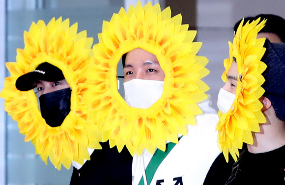 해바라기 분장한 진, 제이홉, 슈가  유럽투어를 마친 그룹 방탄소년단 멤버가 10일 오후 인천국제공항을 통해 귀국하고 있다.  진, 제이홉, 슈가가 해바라기 분장으로 팬들에게 인사하고 있다. 2019.6.10 연합뉴스