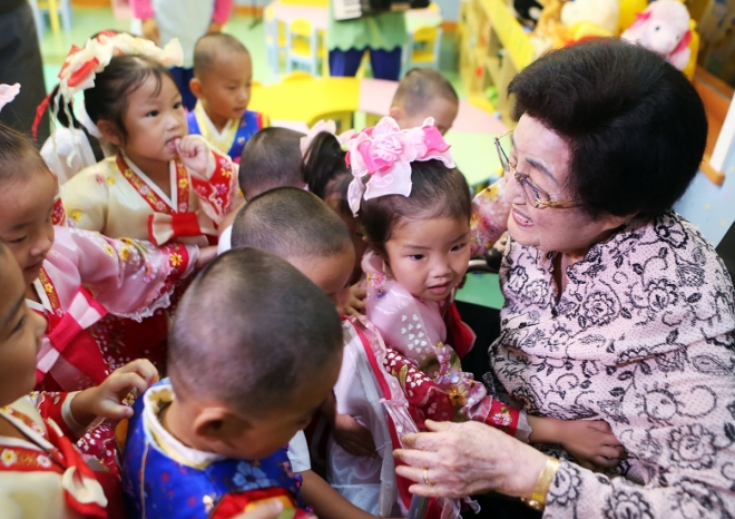 2015년 8월 3박 4일간의 일정으로 북한을 방문한 이희호 여사가 6일 평양의 한 육아원을 방문해 어린이들을 안아주고 있다. 북한에서 육아원은 유치원 취학 전의 고아를, 애육원은 유치원 나이의 고아를 돌보는 곳이다. 2015.8.8  김대중평화센터 제공