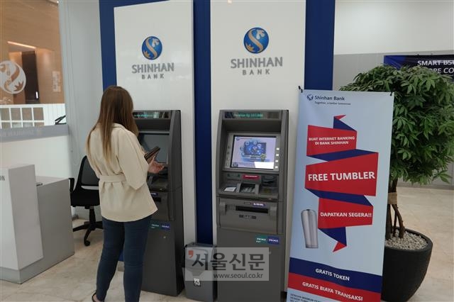 지난달 10일 인도네시아 자카르타에 있는 신한인도네시아은행 본점을 찾는 한 고객이 현금인출기(ATM)를 이용하고 있다. 인도네시아 국민들은 ATM을 송금, 출금뿐 아니라 간편결제를 위한 충전에도 활용한다.