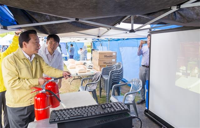 노현송 강서구청장이 지난 7일 열린 ‘제2회 강서 재난안전체험 박람회’에 참석해 소화기 작동법을 교육받은 뒤 직접 사용해보고 있다. 강서구 제공