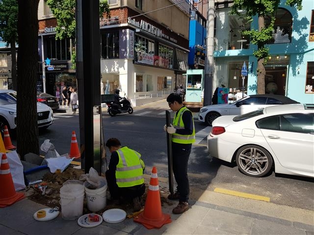 강남구 하수악취제거팀원들이 신사동 가로수길에 ‘지주형 악취차단시설’을 설치하기 위해 땅을 파고 있다.