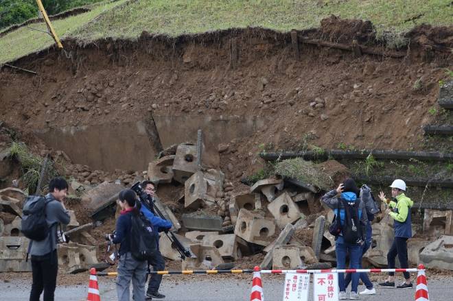 18일 밤에 규모 6.4의 지진이 덮친 일본 니가타현 무라카미시의  무너져 내린 언덕 주변으로 19일 취재진들이 모여들었다. 2019.6.19  AFP 연합뉴스
