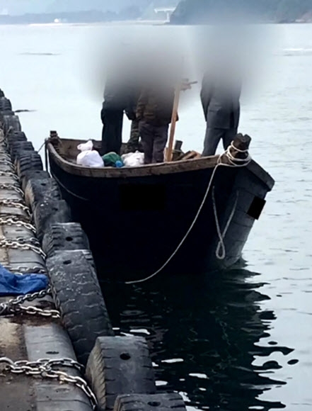 지난 15일 북한 선원 4명이 탄 어선이 연안에서 조업 중인 어민의 신고로 발견됐다는 정부 당국의 발표와 달리 삼척항에 정박했다고 KBS가 18일 보도했다. 사진은 북한 어선이 삼척항 내에 정박한 뒤 우리 주민과 대화하는 모습. 2019.6.18 KBS 제공 
