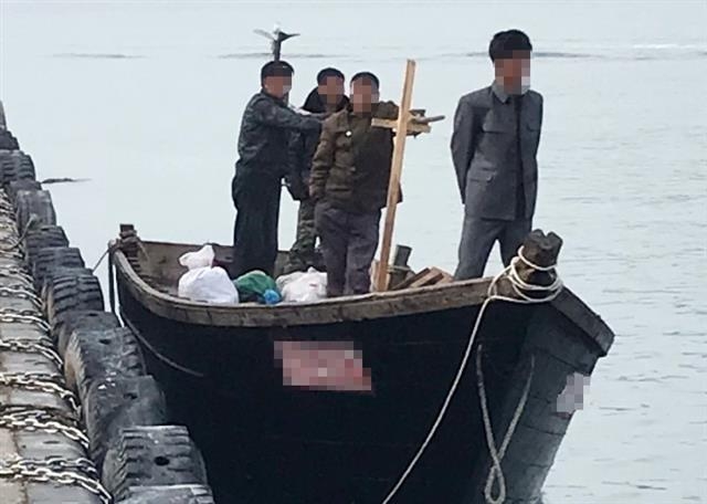지난 15일 북한 선원 4명이 탄 어선이 연안에서 조업 중인 어민의 신고로 발견됐다는 정부 당국의 발표와 달리 삼척항 부두에 정박했다고 KBS가 18일 보도했다. 사진은 당시 삼척항 부두에 정박한 북한어선과 어민. 2019.6.19 뉴스1