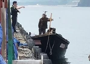 지난 15일 북한 선원 4명이 탄 어선이 연안에서 조업 중인 어민의 신고로 발견됐다는 정부 당국의 발표와 달리 삼척항 부두에 정박했다고 KBS가 18일 보도했다. 사진은 당시 북한 선원들이 삼척항 부두에 정박한 뒤 주민과 대화를 나누는 모습. 2019.6.19 뉴스1