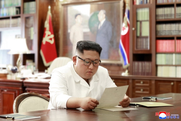 김정은 북한 국무위원장이 집무실에서 도널드 트럼프 미국 대통령의 친서를 읽고 있는 모습을 23일 조선중앙통신이 보도했다.  평양 조선중앙통신 연합뉴스
