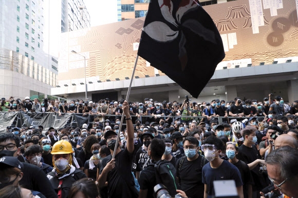 중국 정부의 입김이 강해지면서 대규모 시위가 연일 계속 되는 바람에 홍콩의 위상이 크게 흔들리고 있다. 사진은 1000여명의 홍콩 시민들이 지난 21일 홍콩 경찰청사 앞에서 홍콩 특별행정구기를 흔들며 항의시위를 벌이고 있는 모습. 홍콩 AP 연합뉴스