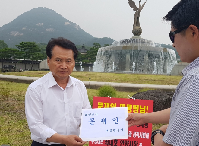 음경택(왼쪽) 안양시의회 의원이 28일 안양시 홍보기획관 부정채용과 관련해 최대호 안양시장이 아무런 조치를 취하지 않고 있다며 청와대 앞에서 1인 시위를 벌인 뒤 관계자에게 민원서류를 전달하고 있다.