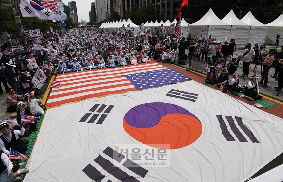 도널드 트럼프 미국 대통령 방한 이틀째인 30일 서울 도심에서는 찬반 집회가 동시에 열렸다. 우리공화당 당원들과 보수단체 회원들은 종로구 청계광장에서 트럼프 대통령 환영 집회를 열고 대형 태극기와 성조기를 바닥에 깐 채 태극기와 성조기를 흔들며 한미동맹 강화를 촉구했다. 오장환 기자 5zzang@seoul.co.kr