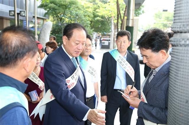 민선 7기 1주년을 맞은 지난 1일 서울 구청장들이 기념식 대신 민생 행보에 나섰다. 유동균(왼쪽 두 번째) 마포구청장이 용강동 상점가를 찾아 시장 상인들과 이야기를 나누고 있다.  마포구 제공