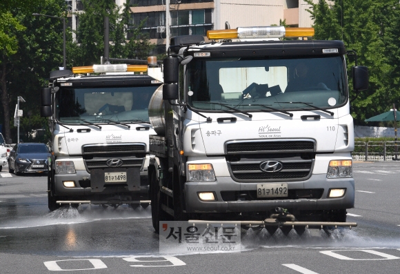 폭염주의보가 내린 4일 서울 송파구 올림픽공원 앞에서 살수차량이 도로위의 열기를 식히기 위해 물을 뿌리고 있다. 2019.7.4 박지환기자 popocar@seoul.co.kr